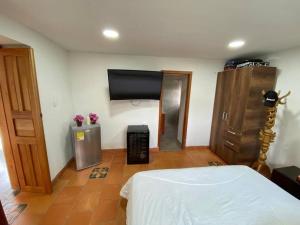 a room with a bed and a flat screen tv at Linda Casa Colonial Remodelada in Guasca