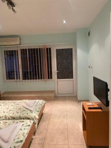 a bedroom with two beds and a television and a door at Sozopol For Two in Sozopol