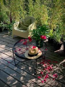 eine Terrasse mit einem Tisch, einem Stuhl und Blumen in der Unterkunft Riverfront Cabins in the garden in Posen