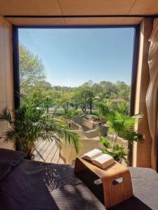 a room with a large window with a view of a garden at Riverfront Cabins in the garden in Poznań