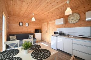 uma cozinha e sala de estar num chalé de madeira em Kalimera em Sarbinowo