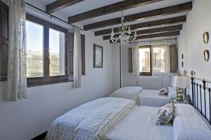 a bedroom with two beds and a chandelier at Casa Rural Martínez in Peñacoba