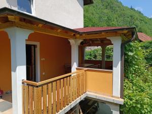 uma varanda com um corrimão de madeira numa casa em Apartma Tija em Tolmin