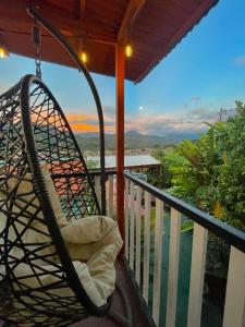 a rocking chair on a balcony with a view at Dreams Lodge Orosi in Cartago