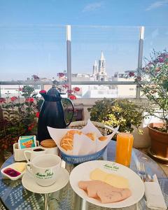 a table with plates of food and a view of a city at Maison verte - Guest House in Arequipa