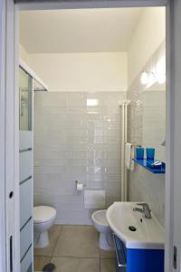 a white bathroom with a sink and a toilet at B&B Peonies in Castellammare di Stabia
