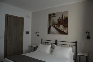 a bedroom with a bed with white pillows and a painting on the wall at Depan Dance in Gallipoli