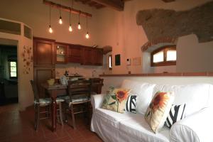 a living room with a white couch and a kitchen at Podere Piana in Reggello