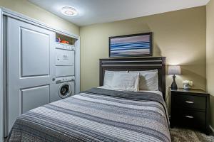 1 dormitorio con 1 cama y lavadora en the Terrace, Best Area, WD, 2 baths, 2 Bedrooms, Jacuzzi Bath, Balcony, 925sf, en Tacoma