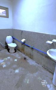 吉尔吉特ABC Hotel的一间带卫生间和水槽的肮脏浴室