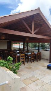 a pavilion with wooden tables and chairs on a patio at Pousada Sunbrazil in Jericoacoara