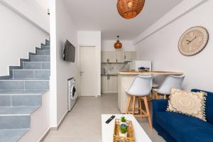 uma sala de estar com um sofá azul e uma cozinha em Suzana's Maisonette em Prinos