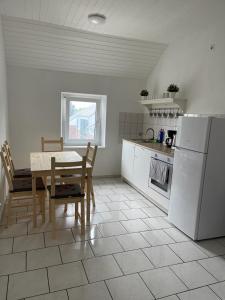 uma cozinha com uma mesa, uma mesa e um frigorífico em City Flats Dortmund em Dortmund