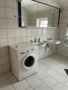 a bathroom with a washing machine and a sink at City Flats Dortmund in Dortmund
