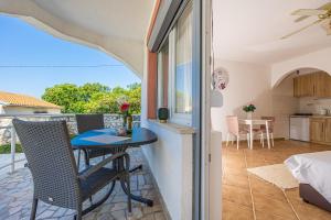 a balcony with a table and chairs and a kitchen at Bella Adria Apartmani in Dramalj