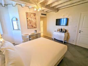 Un dormitorio con una gran cama blanca y una mesa en Casal del pigno en Peschiera del Garda