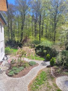 un jardín con una pasarela de piedra y árboles en BukowyRAJ en Łagów