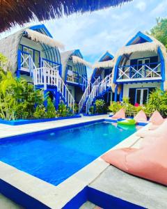 a house with a swimming pool in front of it at Tropical House Bungalows in Gili Trawangan