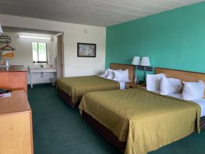 two beds in a hotel room with blue walls at Horseshoe Curve Lodge in Altoona