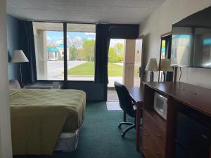 Habitación de hotel con cama, escritorio y ventana en Horseshoe Curve Lodge, en Altoona