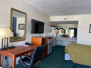 Una habitación de hotel con escritorio, cama y cama y una habitación con en Horseshoe Curve Lodge, en Altoona