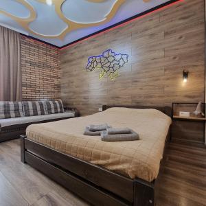 ein Schlafzimmer mit einem großen Bett in einem Zimmer mit Holzwänden in der Unterkunft Petropavlivska apartment in Kamjanez-Podilskyj