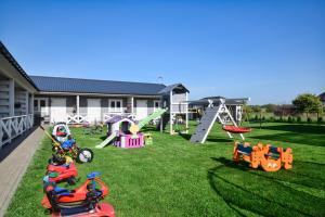 ein Hof mit Spielgeräten für Kinder auf dem Rasen in der Unterkunft Kalimera in Sarbinowo
