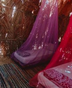 Cama morada con almohadas en el suelo en una habitación en كامب طموسي, en Siwa