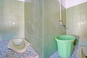 ein Badezimmer mit einem WC und einem grünen Mülleimer in der Unterkunft SPOT ON 92595 Umi Homestay Syariah in Sidoarjo
