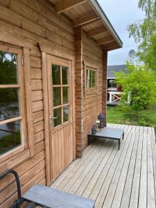 a wooden cabin with a door and a bench on a deck at Cottage Stranden in Kruunupyy