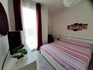 a bedroom with a bed and a tv and a window at Mare e Storia da Sabrina in Sassari