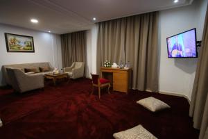 uma sala de estar com um sofá e uma TV na parede em Hôtel Mansour em Dakhla mais 25 fotografias