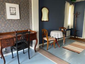 een kamer met een piano en een tafel en stoelen bij Vinter Bed & Breakfast in Sauvo