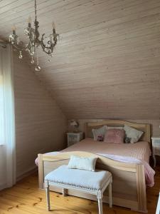 1 dormitorio con cama y lámpara de araña en Sense House -miera oāze pie jūras, en Zvejniekciems