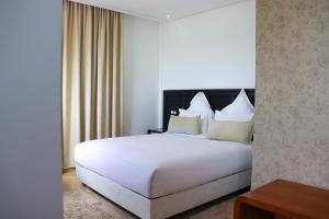 a large white bed in a hotel room at Hôtel Mansour in Dakhla