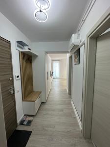 un couloir menant à une chambre aux murs blancs et à un couloir dans l'établissement GlamArt Apartment, à Craiova