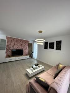 Una sala de estar con un sofá y un televisor. en GlamArt Apartment, en Craiova