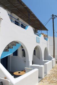 a white building with a wooden table on it at Meltemi Rooms and Studios in Anafi