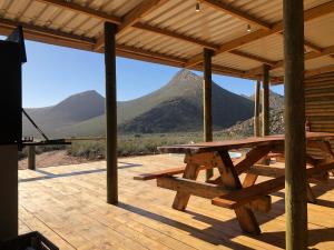 a picnic table on a deck with mountains in the background at Gecko Rock Private Nature Reserve in Goedgemond