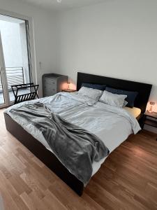 um quarto com uma cama com um cobertor em Moderne Wohnung mit Loggia - Neubau 2023 em Bergisch Gladbach