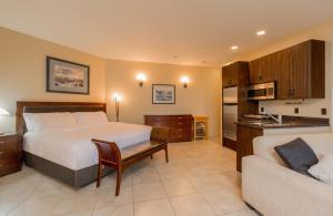 a bedroom with a bed and a couch and a kitchen at Inn the Estuary in Nanoose Bay