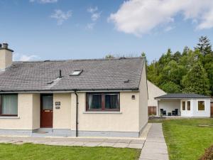 uma casa com um telhado inclinado em Parkhill Cottage em Kildary