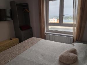 a bedroom with a bed with a stuffed animal on it at LA CASA DE VIOLETA in Suances