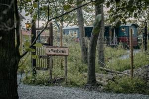 una señal que dice ser watkins al lado de un tren en Pipowagen de Zwerveling aan zee en Oostkapelle