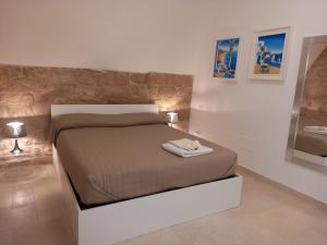 - une chambre avec un lit et un miroir dans l'établissement Suite Duomo Porto Trani, à Trani
