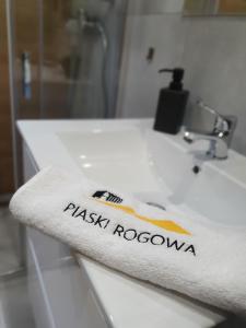a bathroom sink with a wash towel on it at Piaski Rogowa in Rogowo +39 photos
