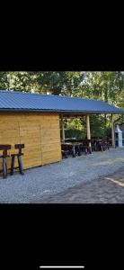 un grupo de mesas de picnic frente a un edificio en Domki u Edzi, en Krajno-Zagórze