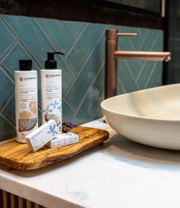 a bathroom counter with two bottles of soap and a sink at La Vista Azul - Sea View Apartment in Pláka