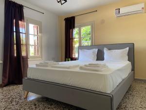 1 dormitorio con 1 cama grande con sábanas y almohadas blancas en Family apartment with 2 bedrooms to the city center, en Kamena Vourla
