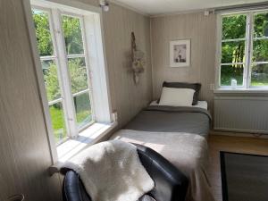 um pequeno quarto com uma cama e 2 janelas em Martebo Bed & Breakfast em Tingstäde